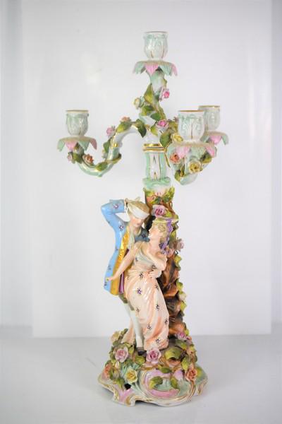 Schierholz Dancing Couple Candelabra: A Candelabra with Dancing Couple and Sculpted Flowers. Marked on Bottom of Base. Colors show well, with High Relief to Sculpture work. Shows wear, including Loss to flowers and missing Fingers on Lady