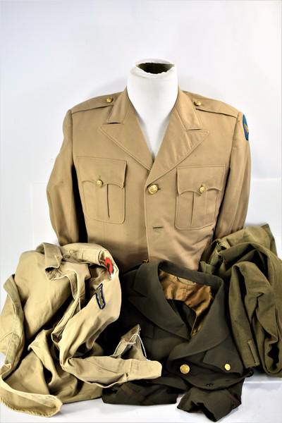 WWII Military Uniform Grouping: Includes a tan Army Air Force uniform with Air Force patch, an Ike Jacket, a tan US Army WWII shirt with Private insignia and 2nd Army patch, a pair of army pants, and a WWII US Army bag.