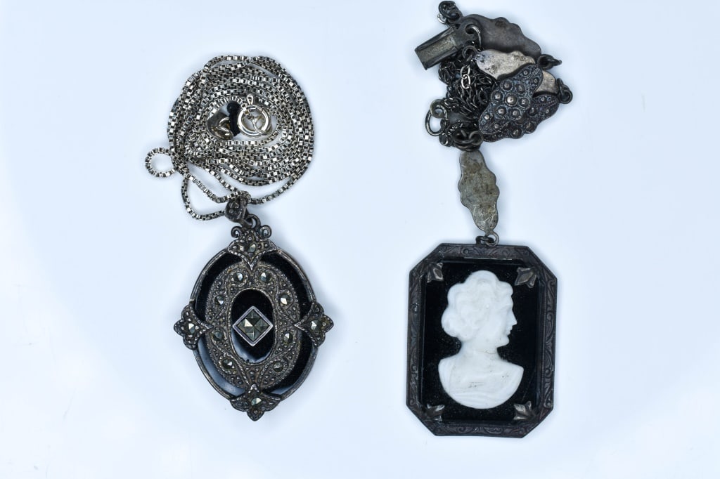 2 Sterling Vintage Necklaces: One black and white cameo (missing part of clasp), the other with black onyx and marcasite. 0.50 ozt total