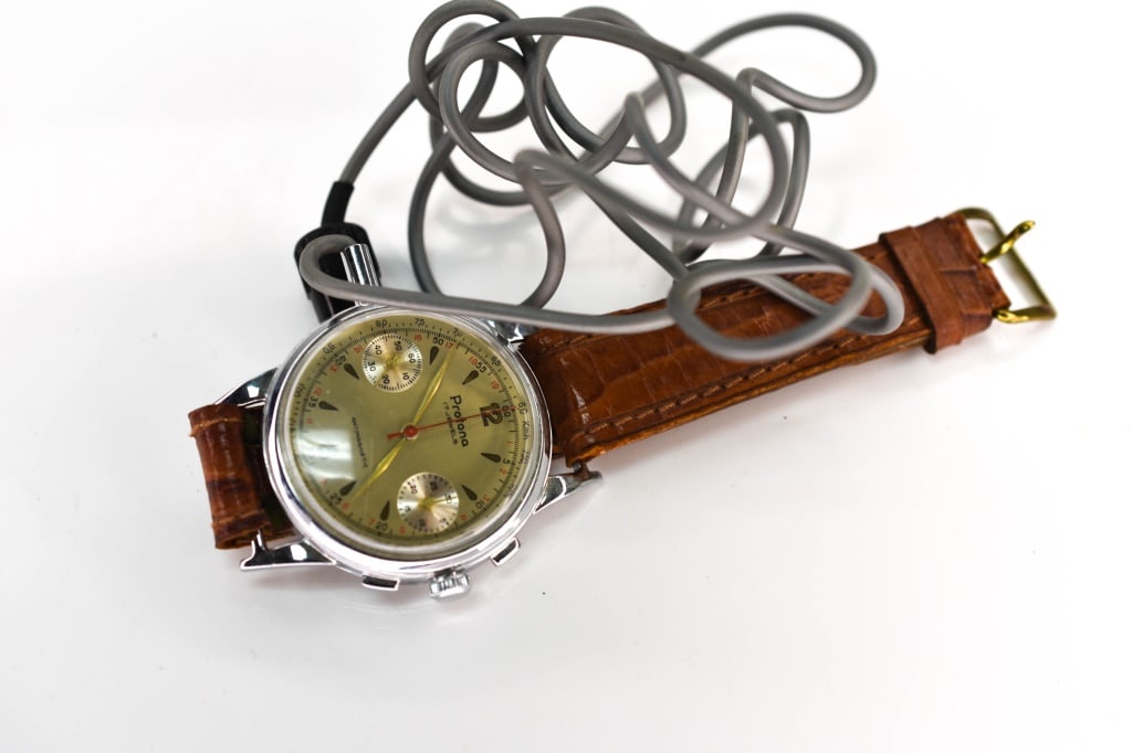 Protona Spy Watch with Microphone: Includes a Protona 1960's spy watch, a rare wrist-worn wire tap microphone pick-up, designed as a watch, probably an MI5 issued watch. Case measures approx. 39mm (outside diameter). Dial is marked Pro