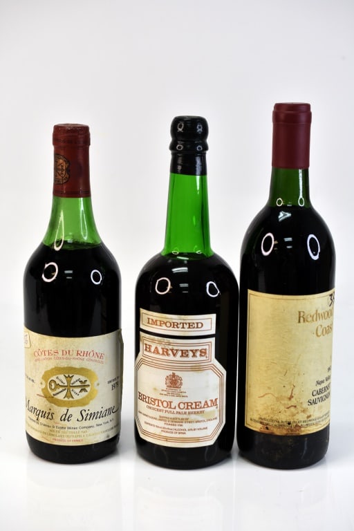 79' Marquis de Simiane Cotes du Rhone Wine & More: Grouping includes (3) bottles including (1) Harveys Bristol Cream Pale Sherry, (1) 1979 Marquis de Simiane Cotes du Rhone, and (1) 1982 Redwood Coast Napa Valley Cabernet Sauvignon. This fine wine is 