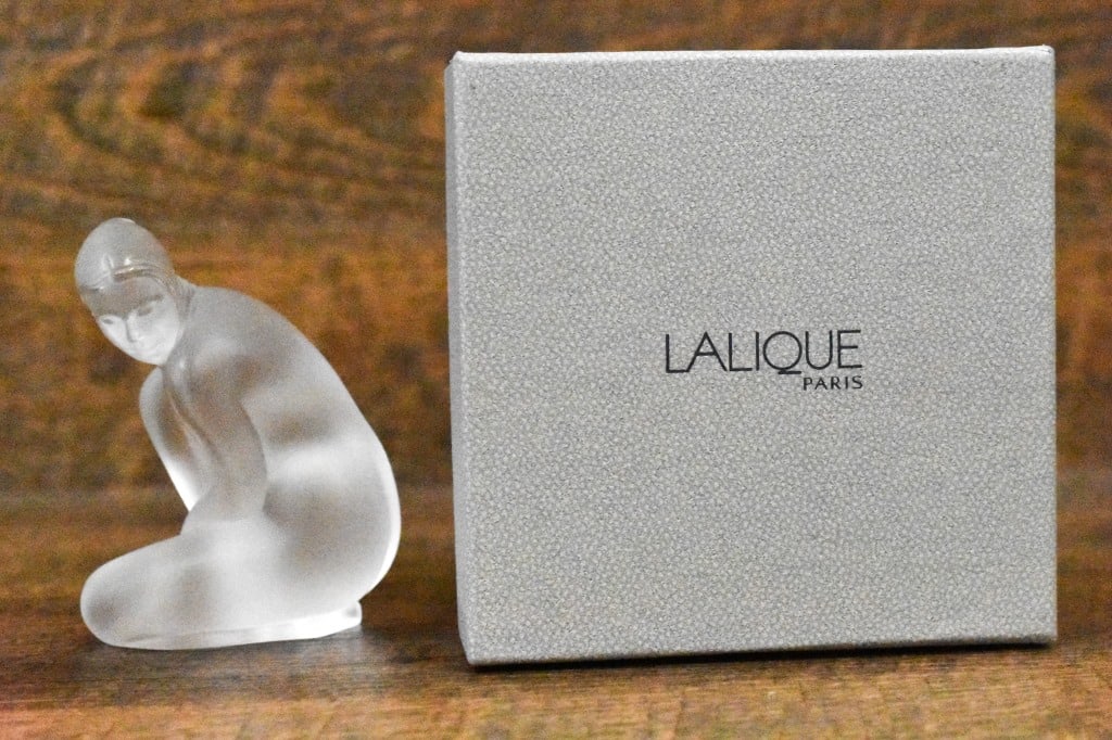 Lalique Crystal Figurine Venus Nude W/Box: A frosted crystal figural modeled as a nude woman kneeling. Lalique France. Signed. Approx. dimensions L: 2.5" W: 3" H: 4". Includes original fitted box and document.