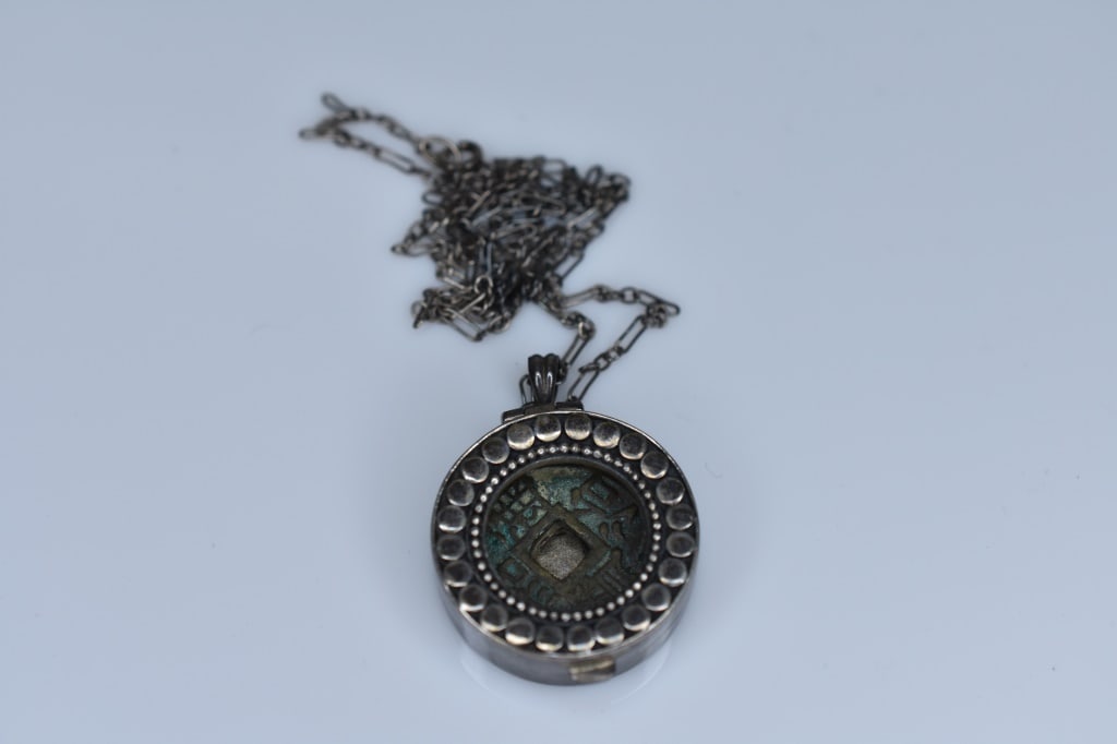 Sterling Silver Locket Housing Chinese Coins: Sterling 22" chain supporting open front locket with various coins, 0.90 ozt total.
