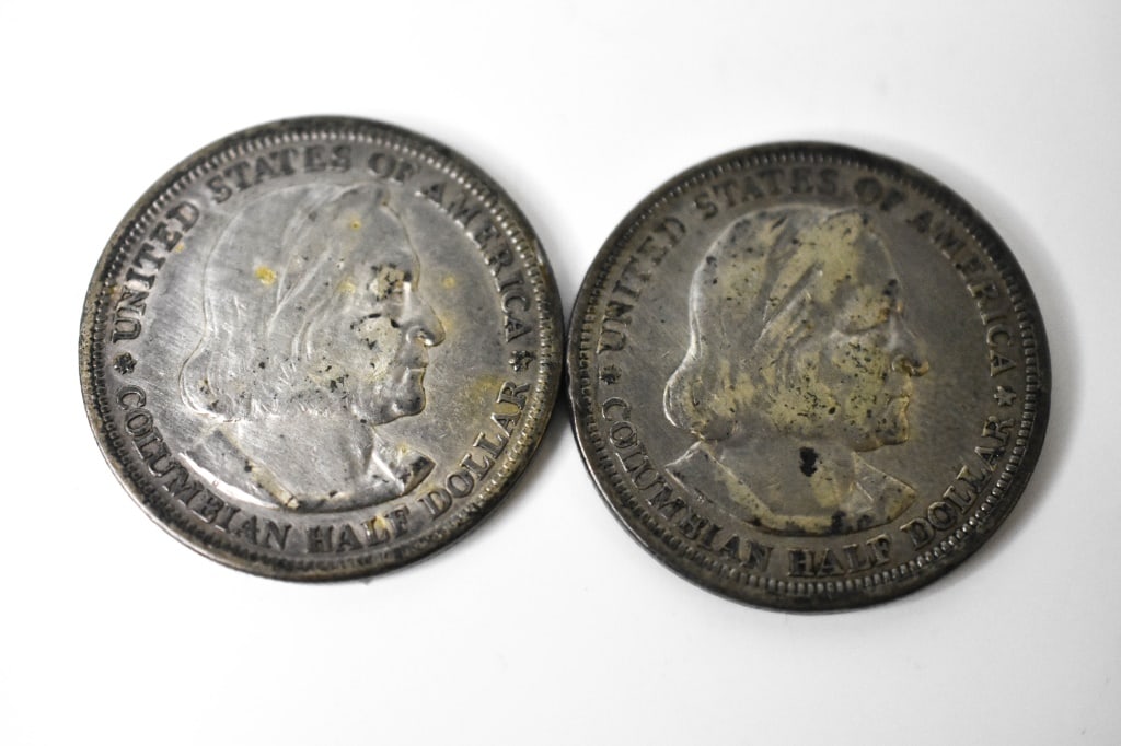 2 1893 Columbian Exposition Silver Half Dollars: They show light wear from storage. Dark in areas. Lines in the sail and globe show wear. $1.00 face in Silver.