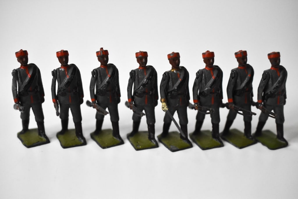 Britains Lead Montenegrin Infantry Soldiers: 7 infantry and 1 officer. Movable right arms. Roughly 2.25 inches tall. In used condition with paint loss. Some bends in the rifles.