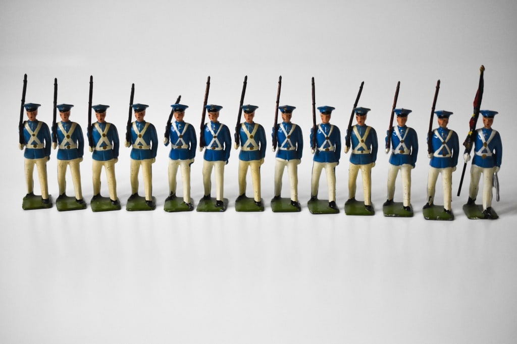 Britains Boxed set No 2098 Venezuelan Cadets: 13 lead figures. 12 with rifles and 1 flag bearer. Flag bearer right arm has damage. Some age cracks in the paint jobs on some of the soldiers. Paint loss is common. Roughly 2.25 inches tall. Has the