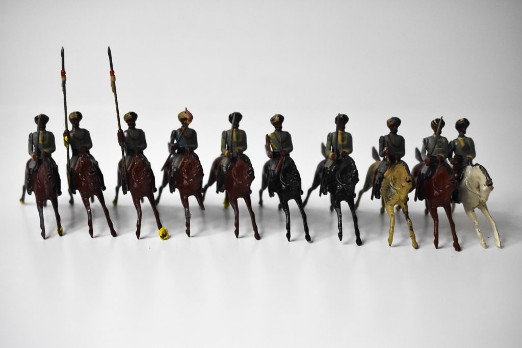 10 Britains Lead Indian Army Lancers: About 3 inches wide. Blue grey looking uniforms. 1 trumpeter and officers horses have damage. Some blue and yellow putty was used to help hold the arms and horses in place. Putty is easily removed. Pl