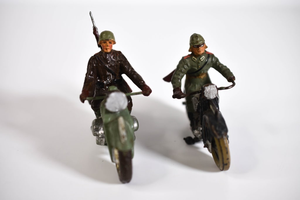 2 German Composition Army Motorcycles: Black 1 has tin wheels, fender, and small wheels. Rest is Composition, with paint loss. Rifle is broken and the stock is a poor repair. Other is marked elastolin. Rifle is not whole. Both have typical