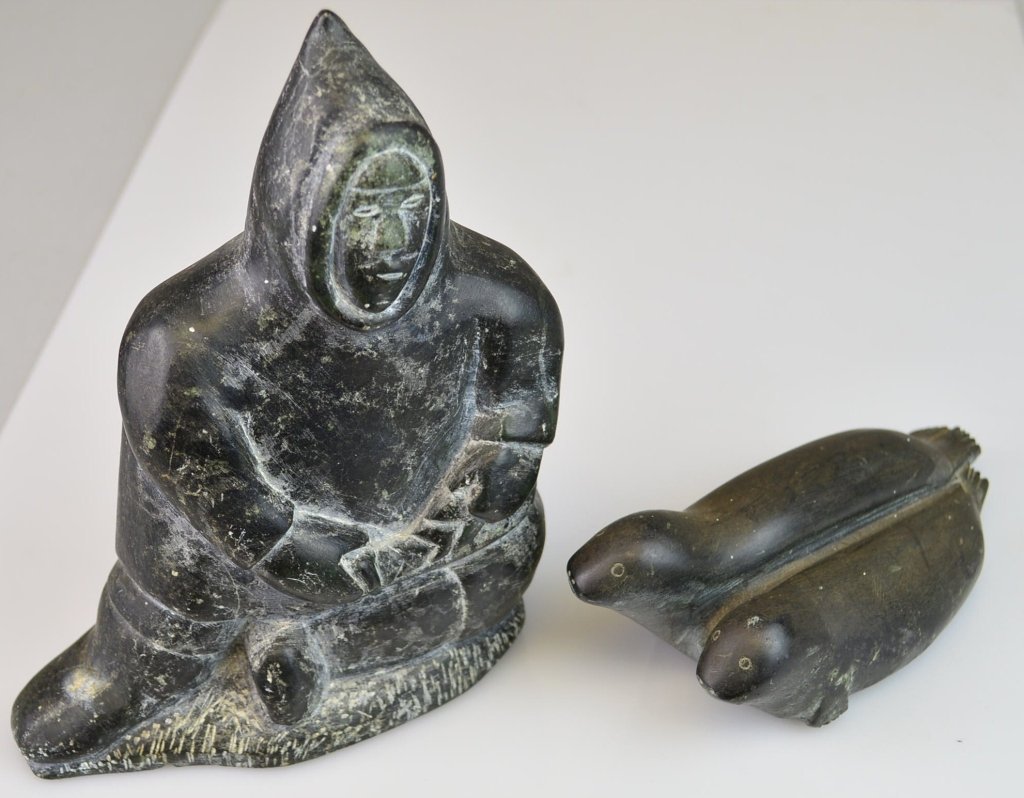 Inuit Stone Sculptures Lot: Eskimo and fish and Seal and cub. Eskimo measures 7 x 5". Seal 5.5" x 2.25""