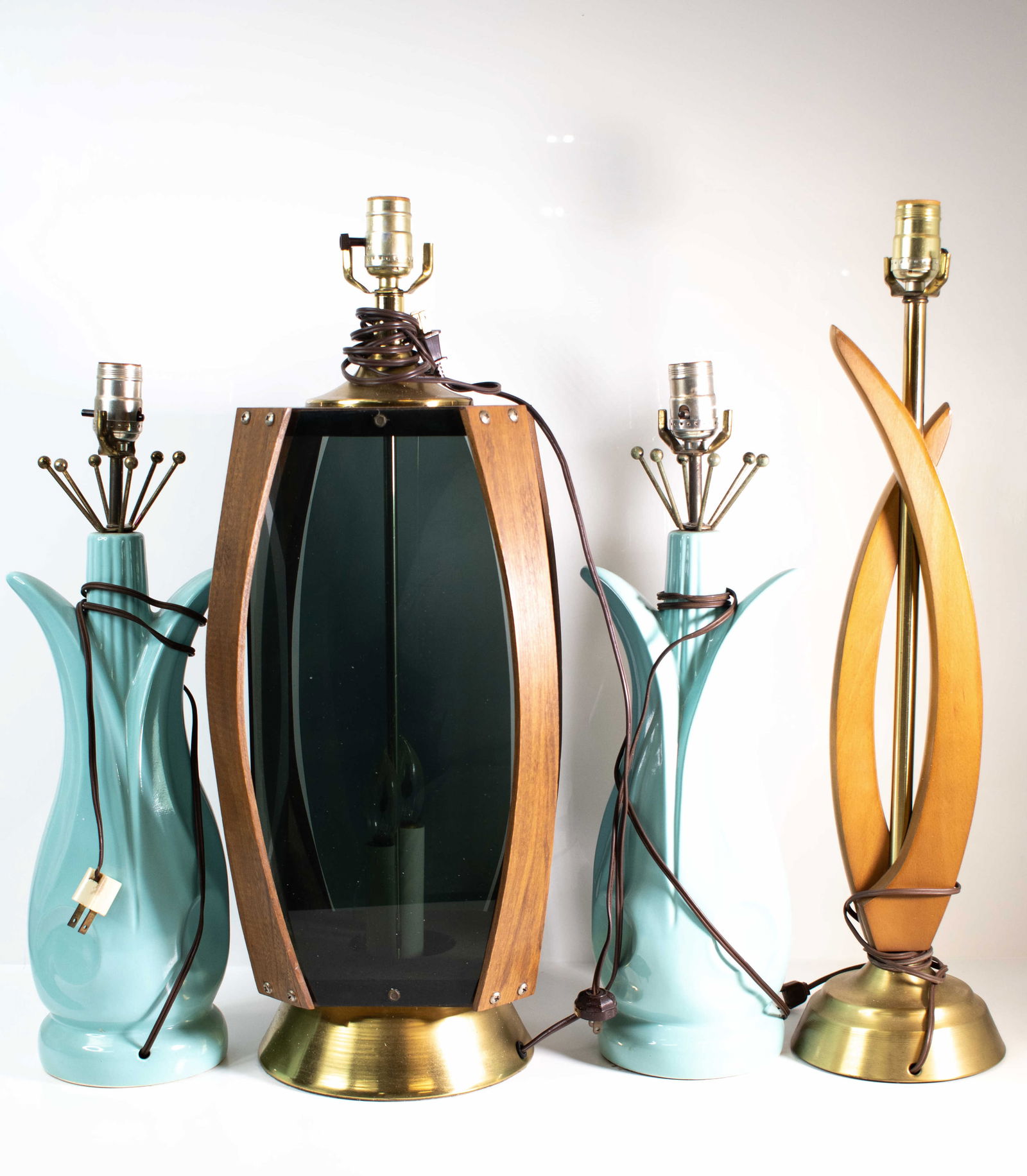 Mid-Century & Adrian Pearsall Style Table Lamps: A varied group of four mid-century modern table lamps, assembled in complementary materials and forms. The group includes two ceramic examples in a soft turquoise glaze with flared, organic profiles;