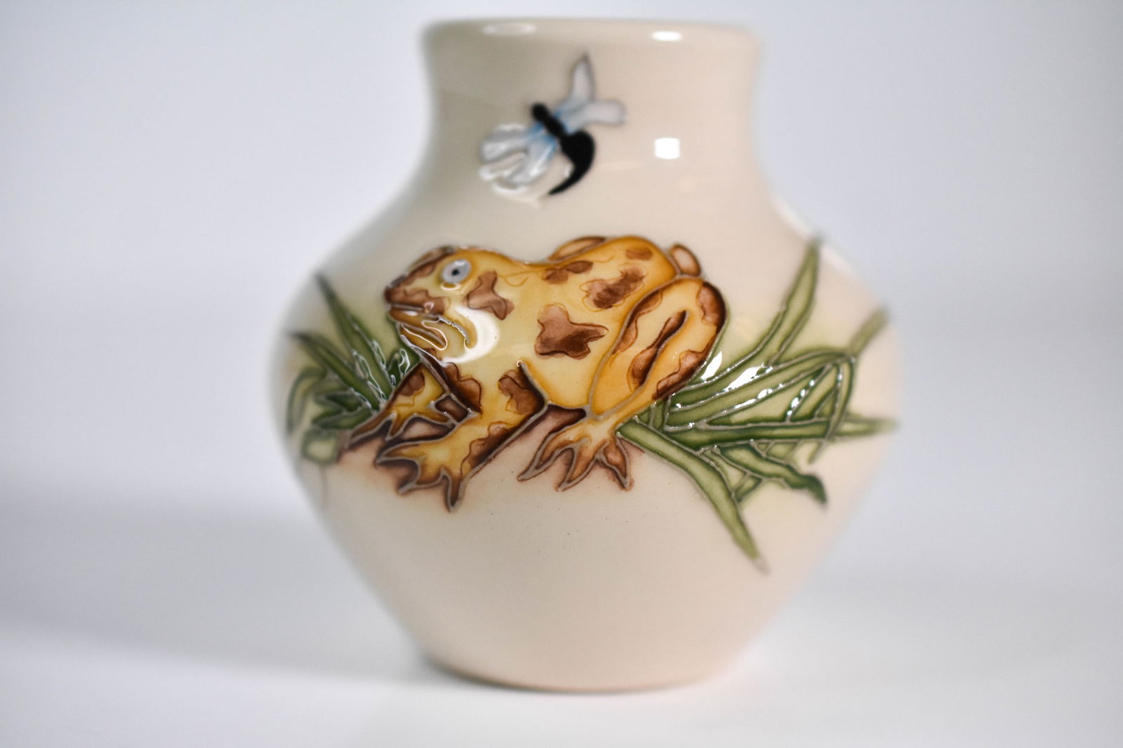 Moorcroft “Frog and Dragonfly?? Vase 2009: "A charming Moorcroft pottery vase designed by Kerry Goodwin, decorated in the lively “Frog and Dragonfly” pattern. The piece features playful green frogs and delicate dragonflies amid reeds