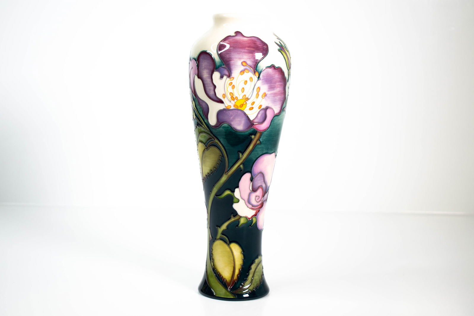 Moorcroft “Rose?? Vase by Kerry Goodwin: A beautiful Moorcroft pottery vase titled “Rose,” designed by Kerry Goodwin in 2013. The design features elegant, full-bloom roses in rich shades of red and pink, surrounded by deep green