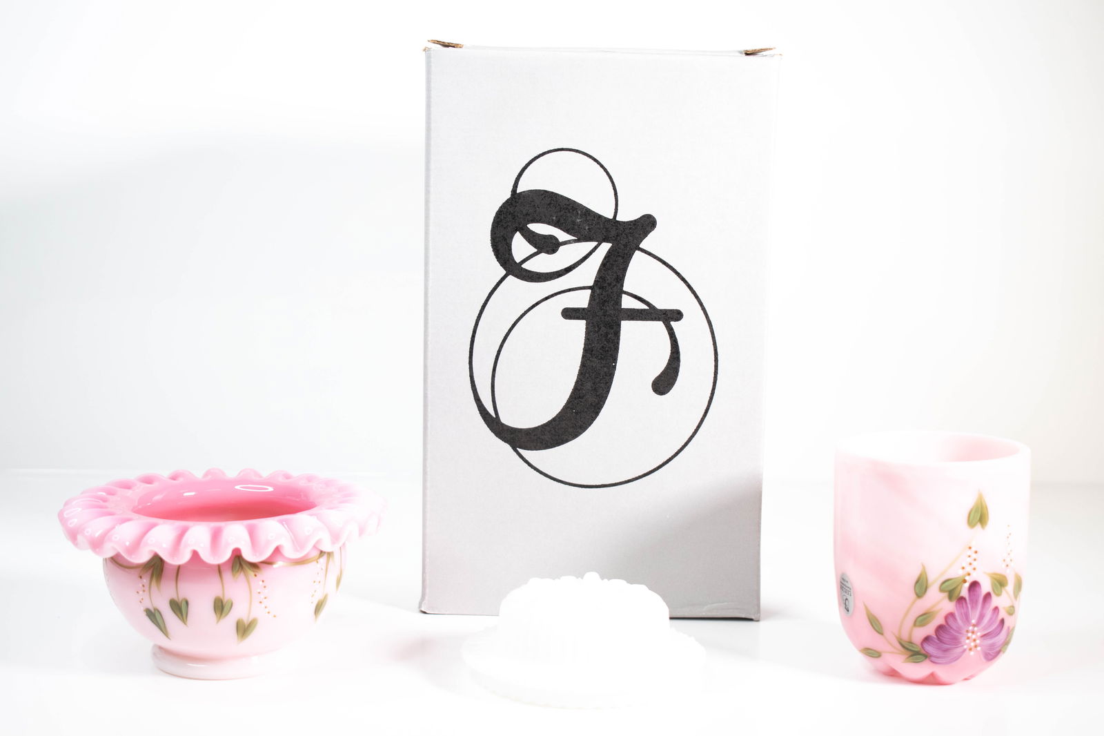 Fenton Hand Painted Glass Vanity Set: This lot consists of a Fenton hand-painted glass group, including a ruffled bowl, a matching tumbler or small vase, and a glass candle holder, accompanied by a Fenton-branded box, as shown. The pieces