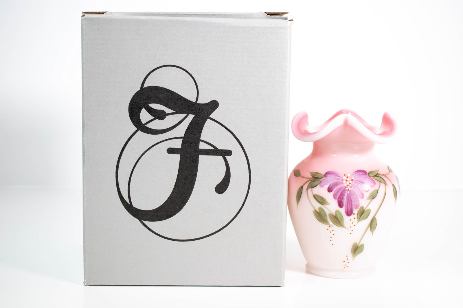 Fenton Rosalene Hand-Painted Vase, Limited Edition: Decorative art glass vase by Fenton, executed in soft pink Rosalene glass with a hand-painted floral motif. The design features a central purple flower with green leaves and gold dot accents, applied