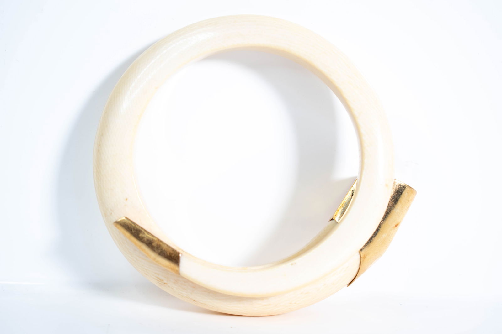Gold Mounted Bone Bangle Bracelet: Gold mounted bone bangle bracelet carved from a natural material. ****We Offer In-House Shipping*** Approximately 3.5"W tests for 14k gold at least.
