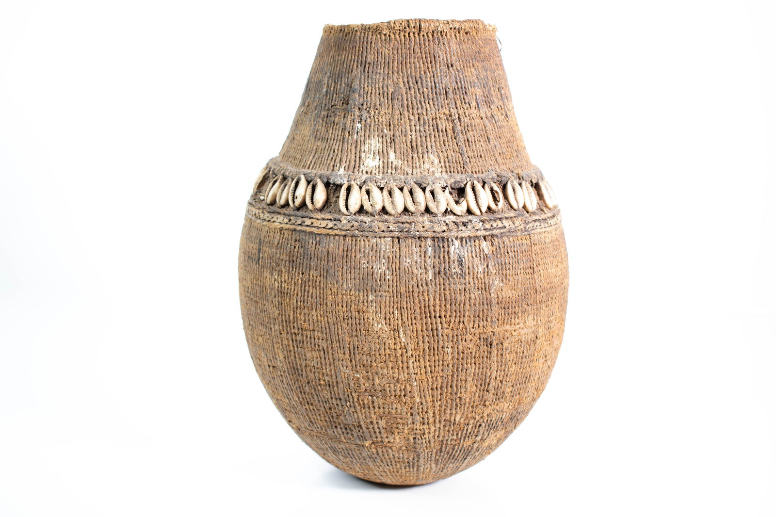 Large African Fiber Vessel with Cowrie Shell Decor: Large African Fiber Vessel with Cowrie Shell Decoration A striking handwoven vessel composed of plant fiber and adorned with a full band of cowrie shells encircling the shoulder. The bulbous body rise
