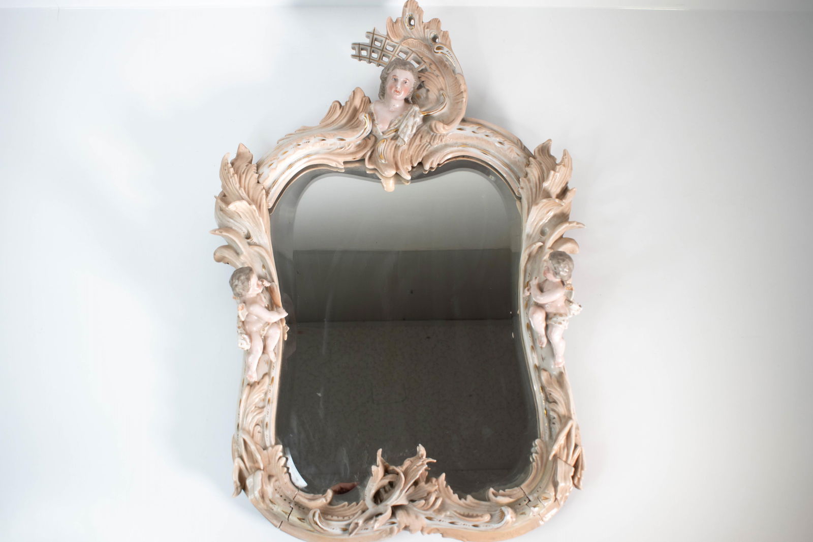 German Dresden Style Figural Mirror: A fine porcelain mirror attributed to Dresden or other fine German porcelain manufacturer. Frame is loose at the seems, but there is no damage. It is assembled of a few different pieces. Height 23"