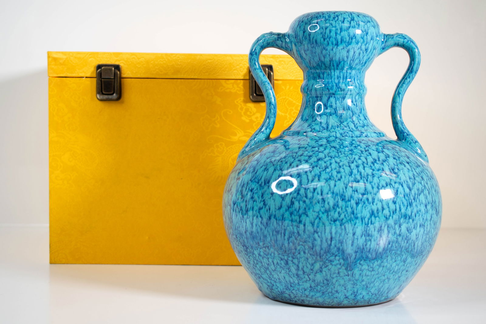 Chinese Monochrome Blue Vase: A two handle vase in a variated Robin's egg blue. in a fitted box. The underside with a Qianlong six character seal mark. of the vase 10"