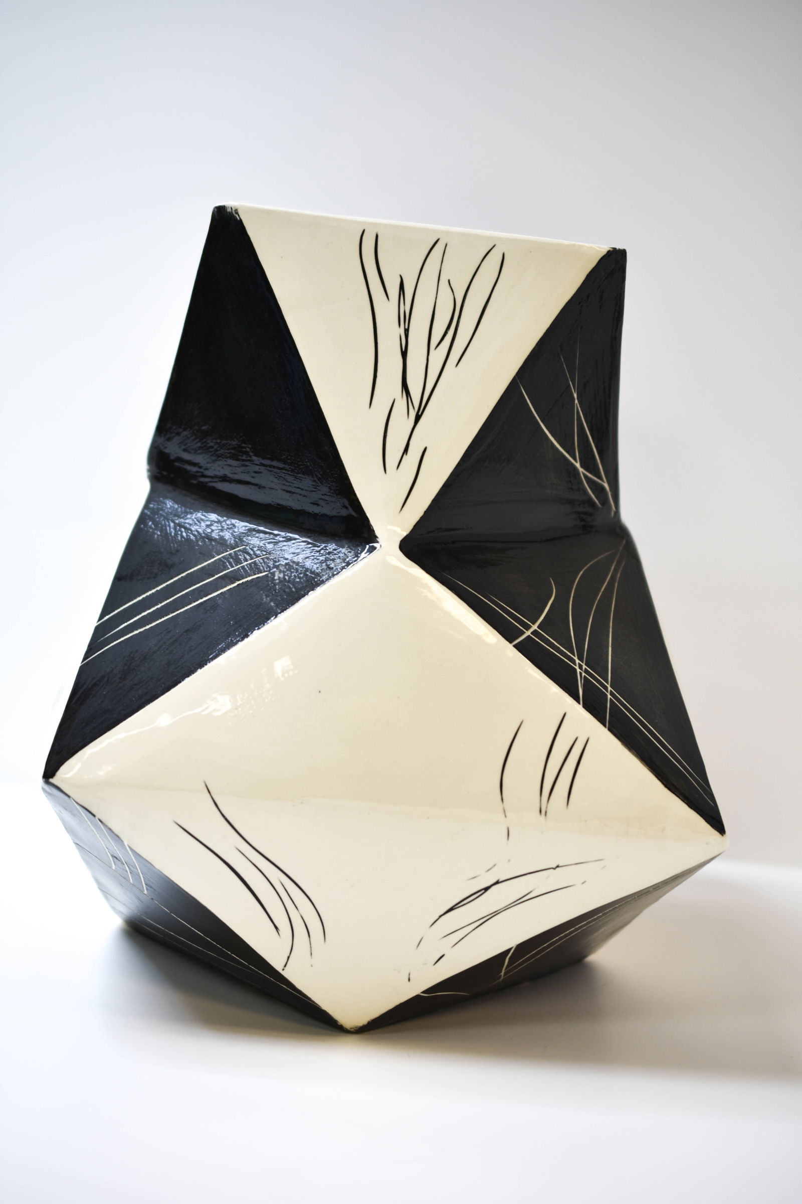 Ricardo Ceramic Vase (Italian) Cubist Movement: An eye-catching geometric ceramic vase, signed "Riccardo" to the base. This hand-built, angular vessel showcases a striking interplay of black and white planes, accentuated with abstract linear incisi