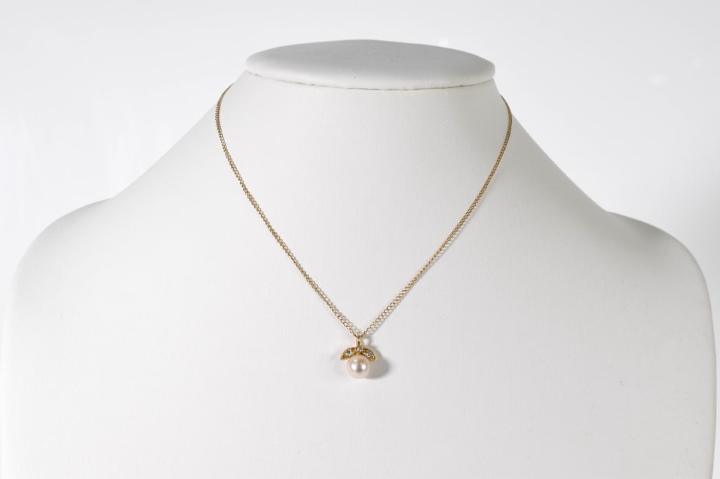 14K Gold Pearl and Diamond Pendant on Chain: 14K yellow gold 15" chain supporting a 14K yellow gold pendant with a 7.5mm pearl accented with 3 full cut diamons: approx. .03 ct each. 1.65 dwt