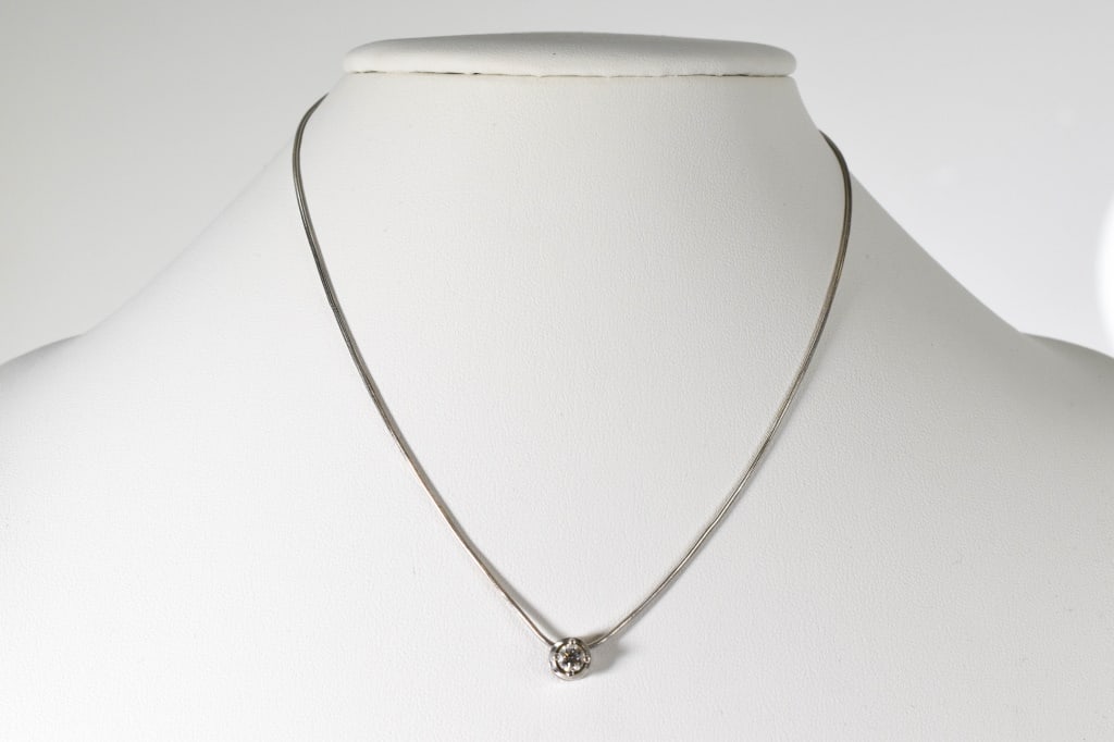 14K Gold & Diamond Slide Pendant on Chain: 14K white gold round pendant containing an approx. 0.35 ct round brilliant cut diamond, supported by a 14K white gold 16" snake link chain. One portion of clasp may have been replaced as it is yellow