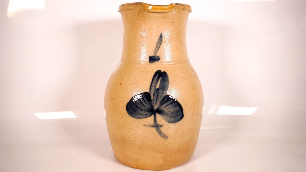 Blue Decorated Floral Stoneware Pitcher: Some roughness on the rim. No makers stamps on it. Almost 11 inches tall. Some black paint on the handle. Don't see any cracks. Some in the making imperfections on the bottom. Will give a slight ring 
