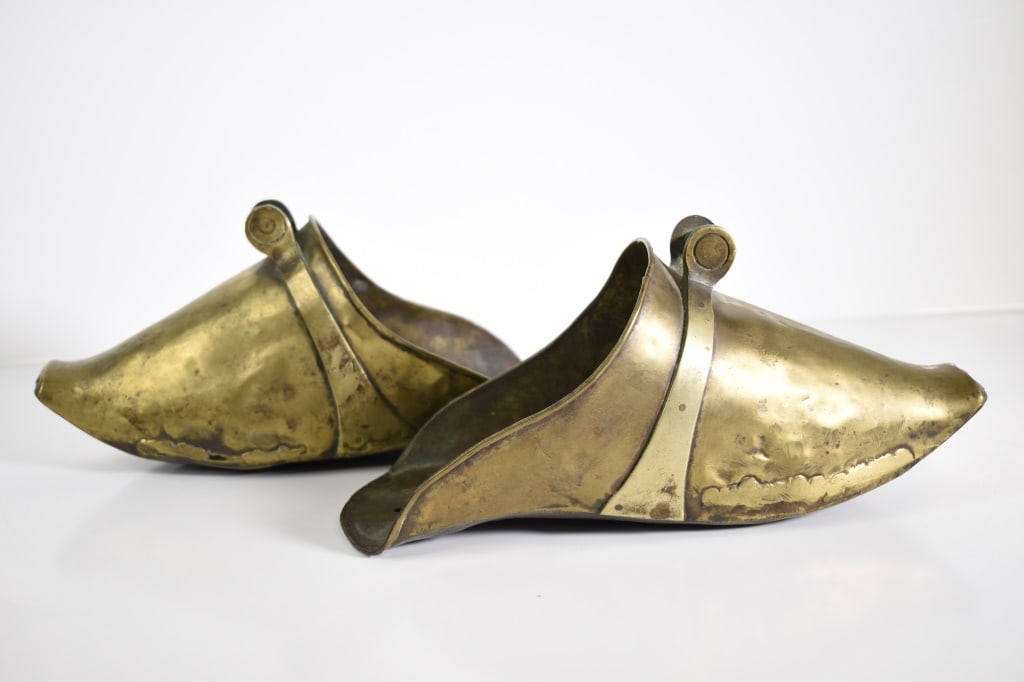 Spanish Style Brass Conquistador Stirrups: Age is not known. No markings. Roughly 10 inches long. Both are dented all over. 1 has a hole one the left side. Provenance: Acquired from a single owner private estate collection originating in Getty