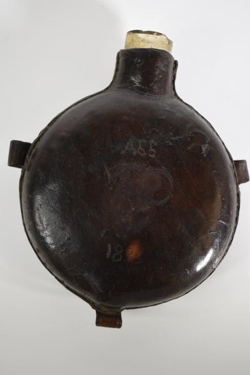 1833 Leather Covered Glass Canteen: No stopper. Chipping out of the opening. No strap. Scratched in the leather A55 1833 on the one side. Leather is hard. 8.25 inches long. Provenance: Acquired from a single owner private estate collect