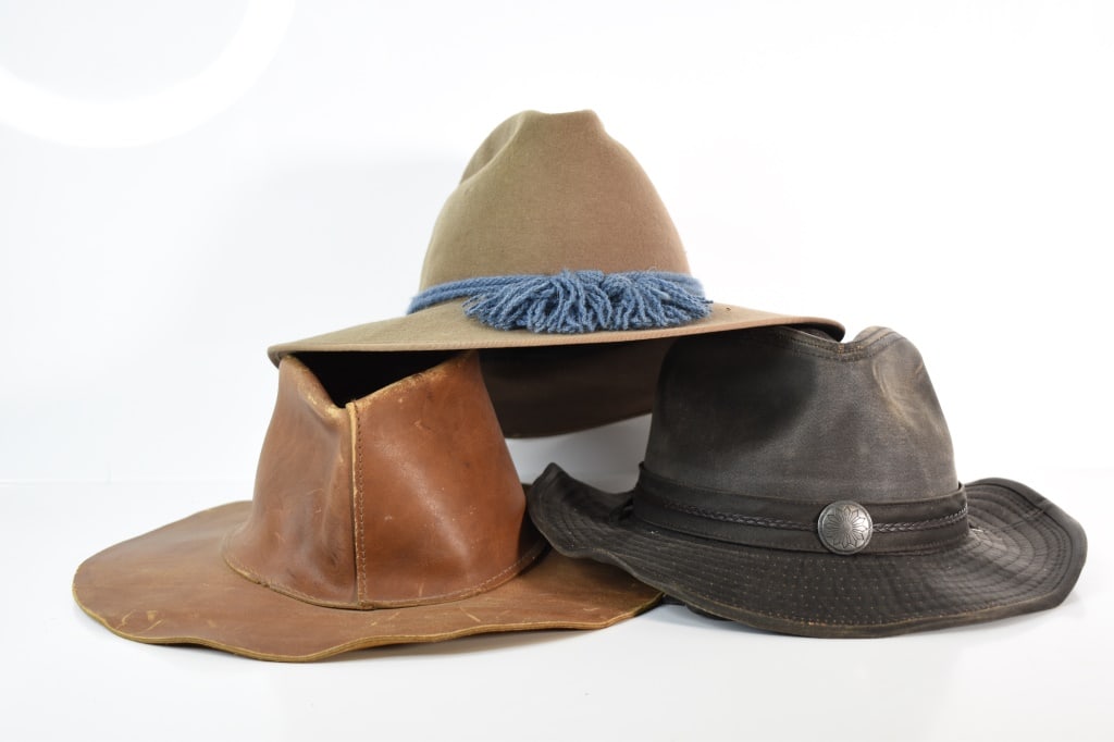 Western Hats Collection (Early & Vintage): Modern. Dark one has a sun design buckle on the front. Leather chinstrap strap. By dorfman pacific co size xl. Other looks like a slouch hat from the 1800s. Modern version though. Last is a leather ha