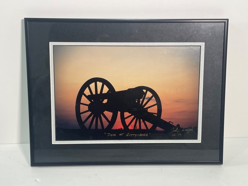Print of Cannon Silhouette: Framed photographic print depicting a silhouette of a cannon against a sunset, titled 'Dusk at Gettysburg.' External dimensions approximately 12 H x 16 W, with a black frame and white matting.