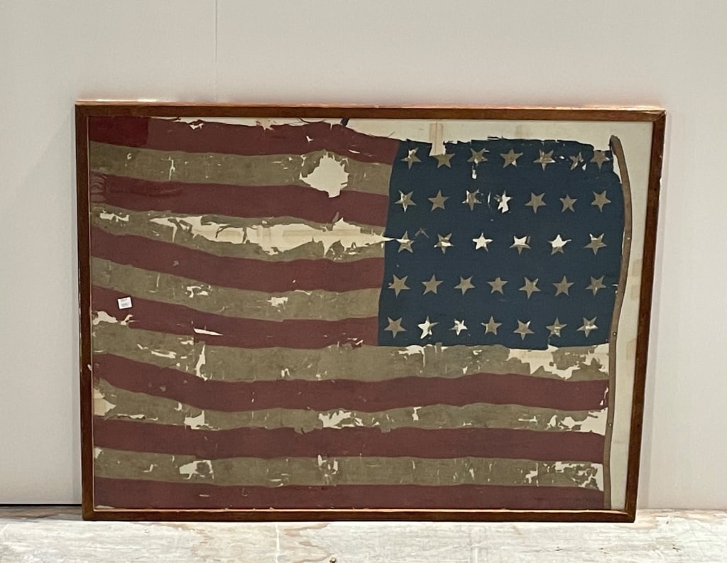 Antique Civil War 25 Star Flag: Framed artwork featuring a depiction of the American flag in a distressed style, showcasing a red, white, and blue motif with stars. Measures 37 inches wide by 27 inches high. Wood frame with glass