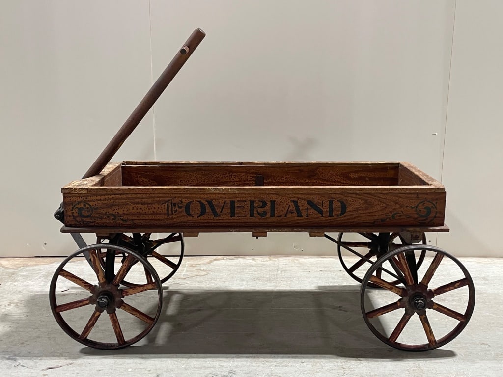 Antique Overland Wagon with Iron Accents: Wood toy wagon featuring iron wheels and accents, with a pull handle and "Loveland" lettering on the side. The wagon measures approximately 36 W x 16 H. A decorative and functional design suitable