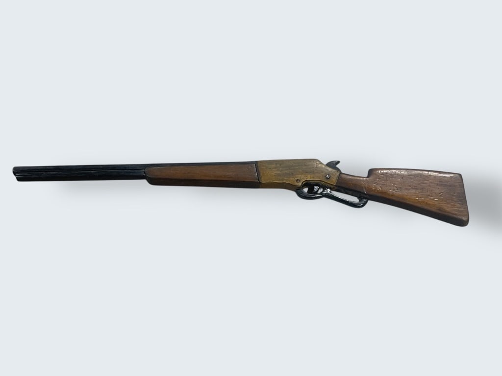 Practice Lever-Action Rifle Replica: Wood and metal lever-action rifle replica measuring approximately 34 H. Features a carved wood stock and forearm with a lever mechanism and a detailed metal barrel. Etched markings visible on the