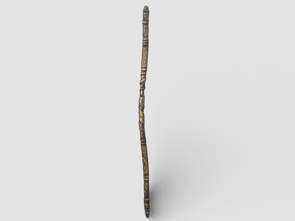 Hand-Carved Wood Walking Stick: Hand-carved wood walking stick featuring intricate carvings, including a bearded figure at the top and various decorative patterns along the shaft. The item measures 38 H and displays detailed