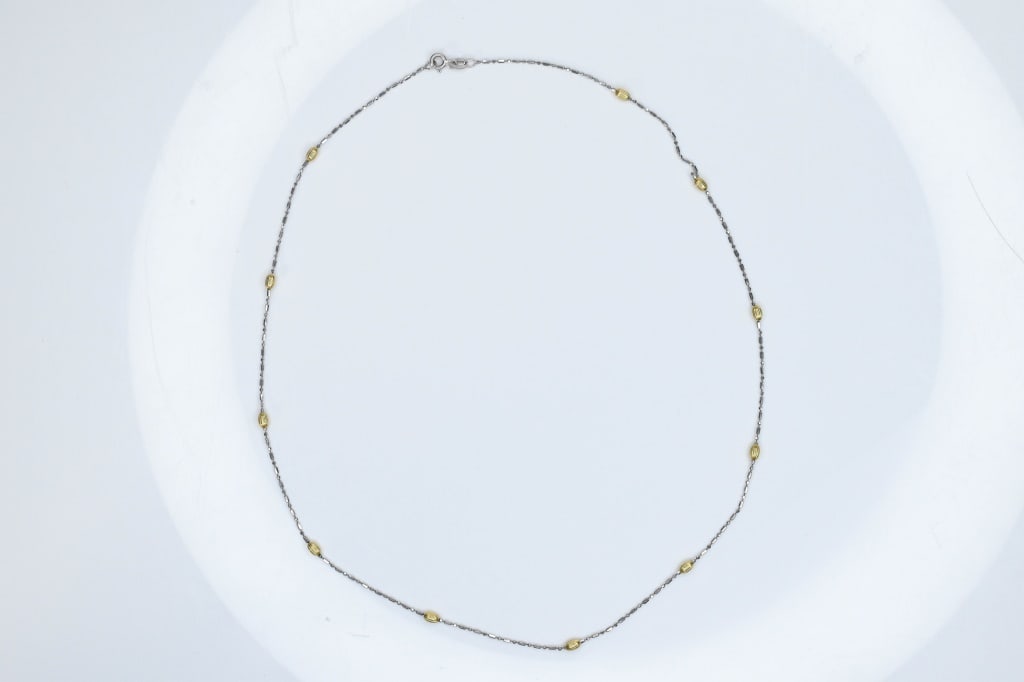 18K Gold Necklace 3.93g: White and yellow with stations needs repair. The overall length measures approximately 20"l.