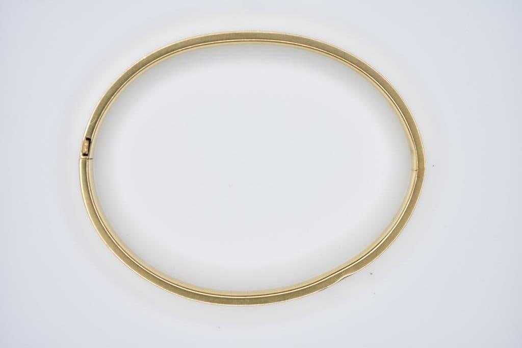 14K Gold Bangle 8.56g: Engraved yellow gold bangle measuring 2.5" wide when closed and 3? open.