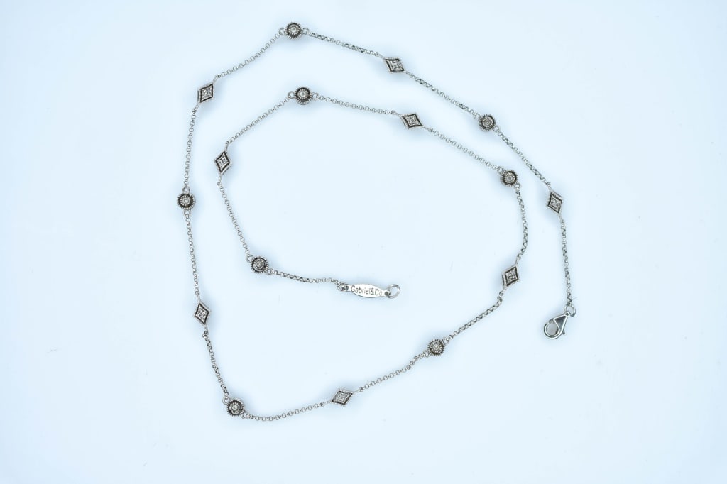 14K Gold Necklace 5.57g: 14K White gold necklace with stations measuring approximately 18" in length and 5.57g in weight.