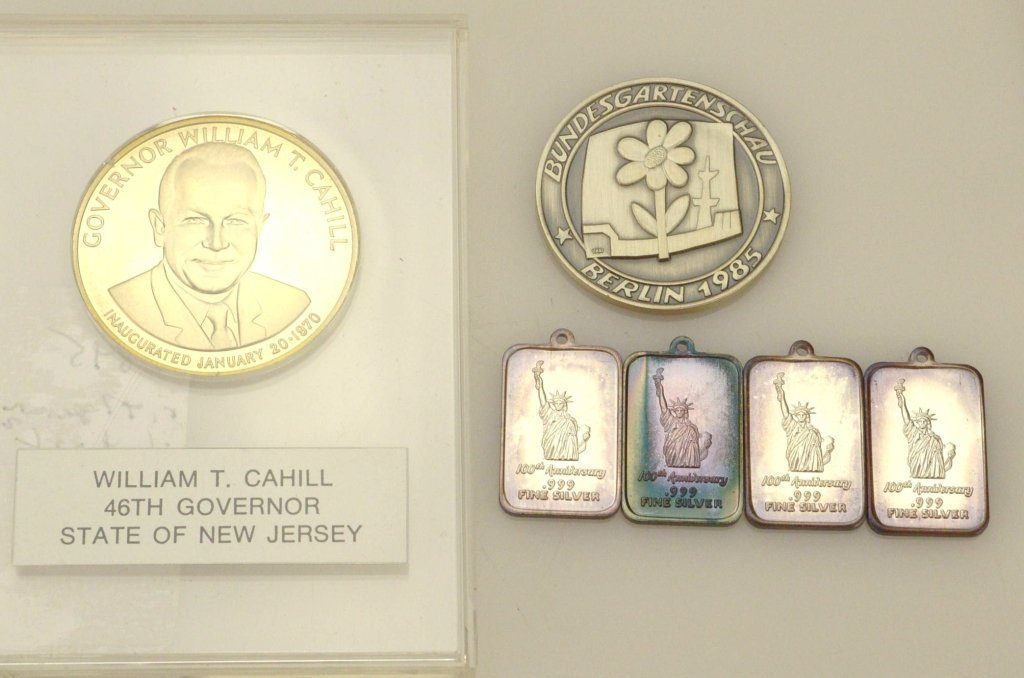 Silver Medallion Lot: Lot includes a Sterling silver inaugural medal for Governor Cahill, a German Horticultural Exhibition medallion marked 1000, and 4 .999 Statue of Liberty Pendants weighing .65 ozt