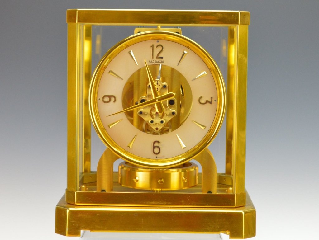 Jaeger LeCoultre Atmos Inca 5090 Clock: A Le Coultre Gilt Brass ATMOS Clock, numbered 45494, Stamped 15 jewels, the silvered ring dial signed LE COULTRE enclosing Arabic and baton chapters encircling an open aperture revealing a movement wo