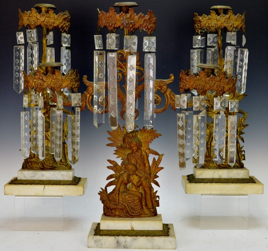 Gilt Brass "Paul and Virginia" Girandole Grouping: Includes the complete set, all with coffin style prisms, and double step marble bases. Marked Dietz Brothers. C. 1875. Center piece measures 17.5" x 19" and the singles measure 6.75" x 16"
