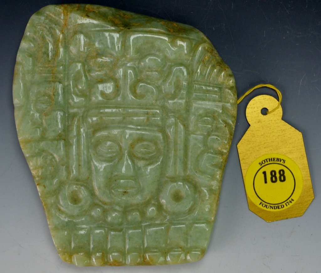 Mayan Jade Plaque : Sotheby's: Late Classic, c. 550-950 A.D. the thick trapezoidal stone carved in relief with a head of a bejewelled warrior wearing an elaborate headdress consisting of an avian (?) head, flanked by human profile 