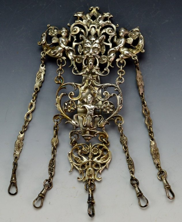 Victorian Sterling Silver Chatelaine: Ornate Chatelaine heavily decorated griffon heads or faces, puttis, flowers, & griffons. Measures 5.5" x 2.75" Hallmark on rear, tests for sterling silver, but unmarked.