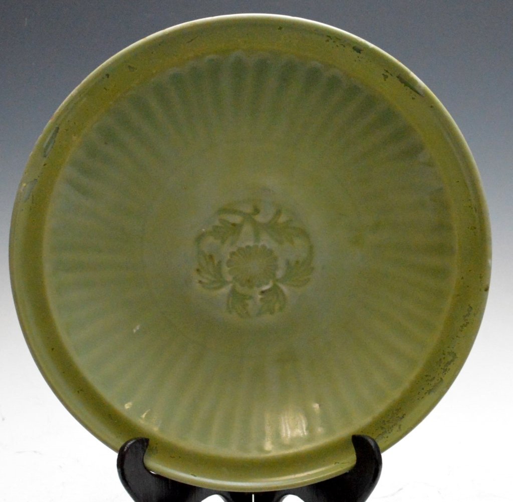 Ming Dynasty Lung Ch'uan Celadon Dish: Lung Ch'uan celadon dish from the Ming Dynasty. The interior impressed in the center with a chrysanthemum spray within a border of radiating petal flutes; the olive green glaze of even tone, rim resto