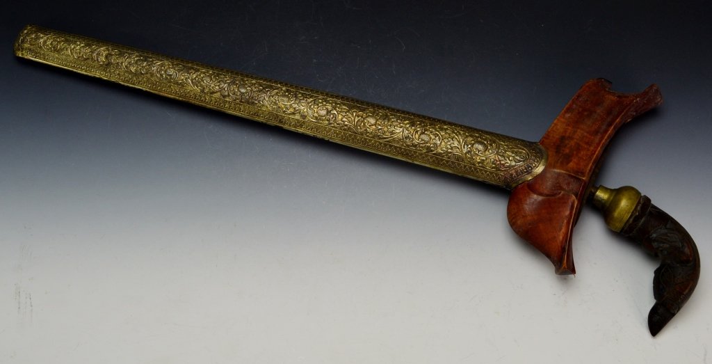 Keris Short Sword: Indonesia, Java. Very early blade, 7 luk, carved hande and warangka. intricately designed sheath. Brass handle cap loose. Measures 17" overall, blade measures 14".