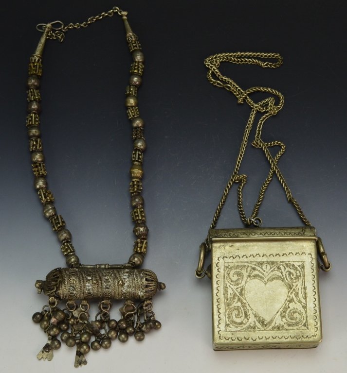 Islamic Military Quran Carriers: Pair of Islamic Persian Quran Carriers. One has etched heart designs, necklace still attached. Measures: 3.5" x 3.5", Second has filigree decoration, and retains original lid. Measures: 3.5" x 4"