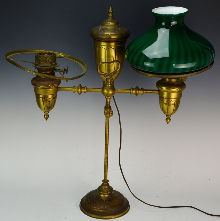 Antique Emeralite Brass Double Arm Student Lamp: Acorn formed reservoirs, resting on a weighted base impressed with a design. Period set-up comprising of electrified E.& M. duplex slip burners, shade rings are in need of repair, one has loose rivet 