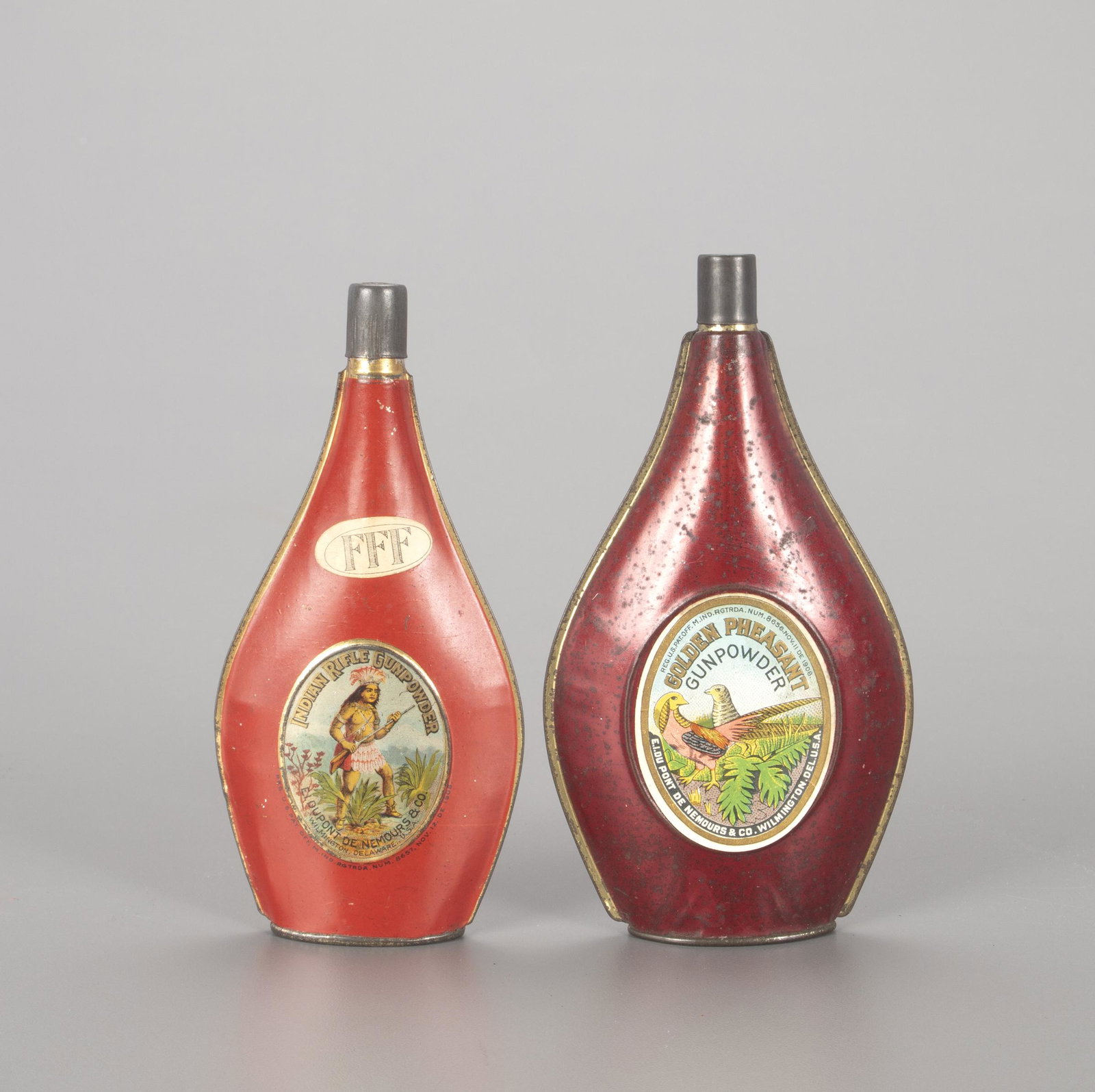 Two du Pont Powder Flasks: Two du Pont Powder Flasks 6 1/4 in. tall Two powder flasks manufactured by the DuPont Co., also known as the E. I. du Pont de Nemours & Co. (1802-2017). One is Indian Rifle Gunpowder, while the other 