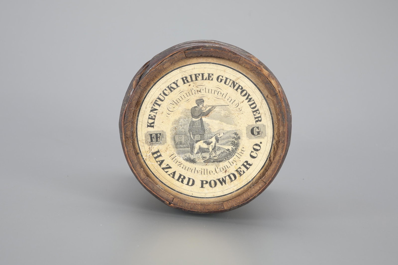 One Kentucky Rifle Gunpowder Keg: One Kentucky Rifle Gunpowder Keg 8 1/2 in. tall Wooden circular keg with "Kentucky Rifle Gunpowder from Hazard Powder Co." label with image of a hunter with a rifle, dog, horse, and birds. As found. P