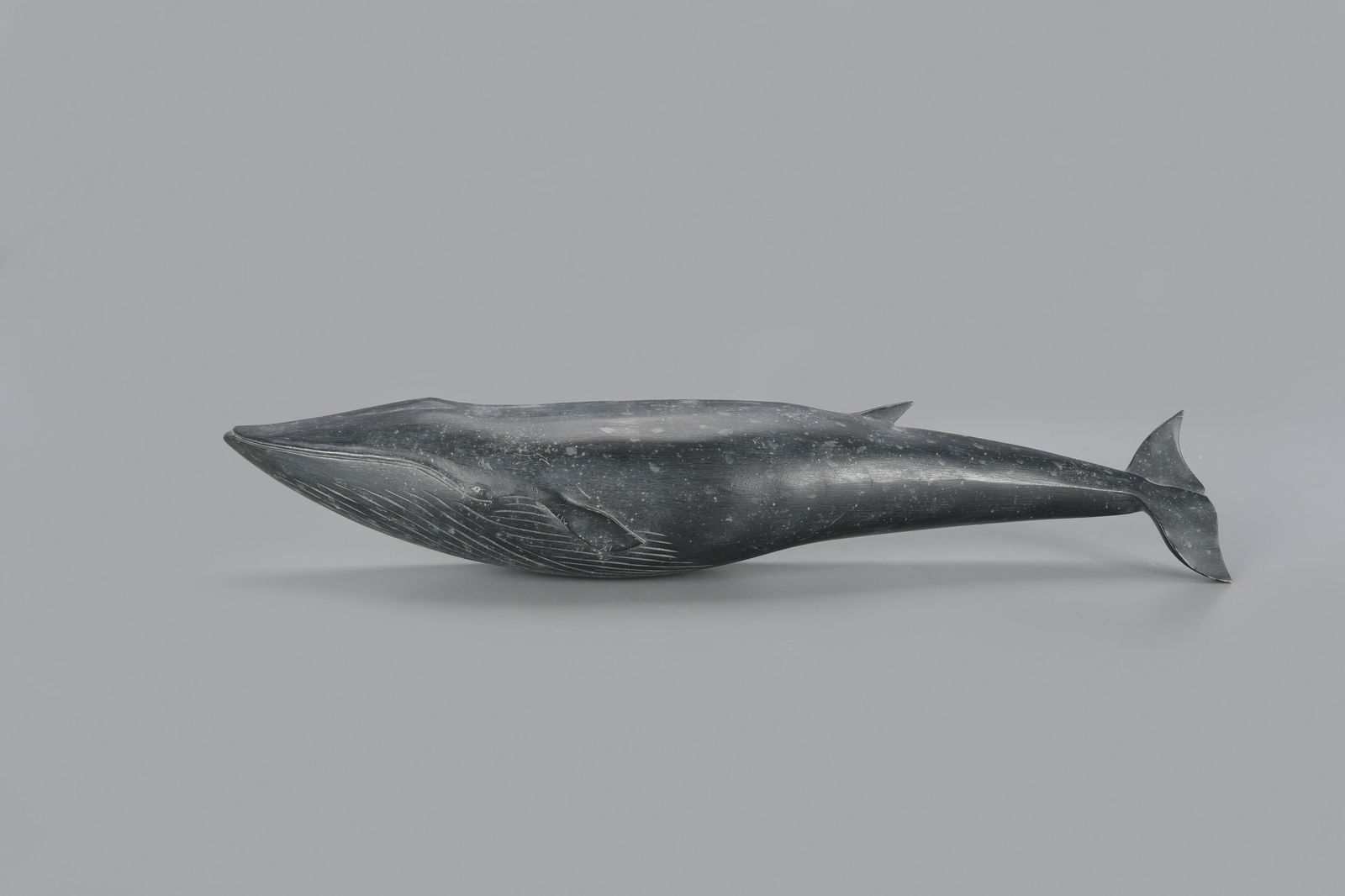 Fin Whale by Clark Voorhees (1911-1980): Fin Whale Clark Voorhees (1911-1980) Weston, VT c. 1960 18 in. long This fin whale carving is signed in the back with a conjoined "CV" and also stamped "C VOORHEES." While he generally painted these w