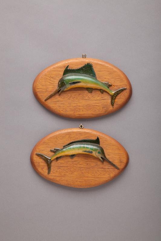 Two Miniature Big Game Fish Plaques: Two Miniature Big Game Fish Plaques Roberts, c. 1950 Original condition. Seven-inch-long marlin and sailfish carvings mounted on oval mahogany plaques measuring five by eight inches. Signed "Roberts" 